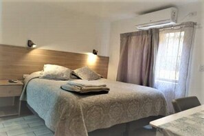 Relax in this serene bedroom with a comfortable bed, bedside table, and chair.