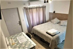 Cozy retreat with a single bed, compact table, and space.