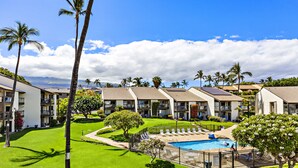 A resort with multiple-story buildings, a swimming pool, and well-maintained lawns. - Cozy Beachside Retreat Steps from Kamaole III (Kihei)