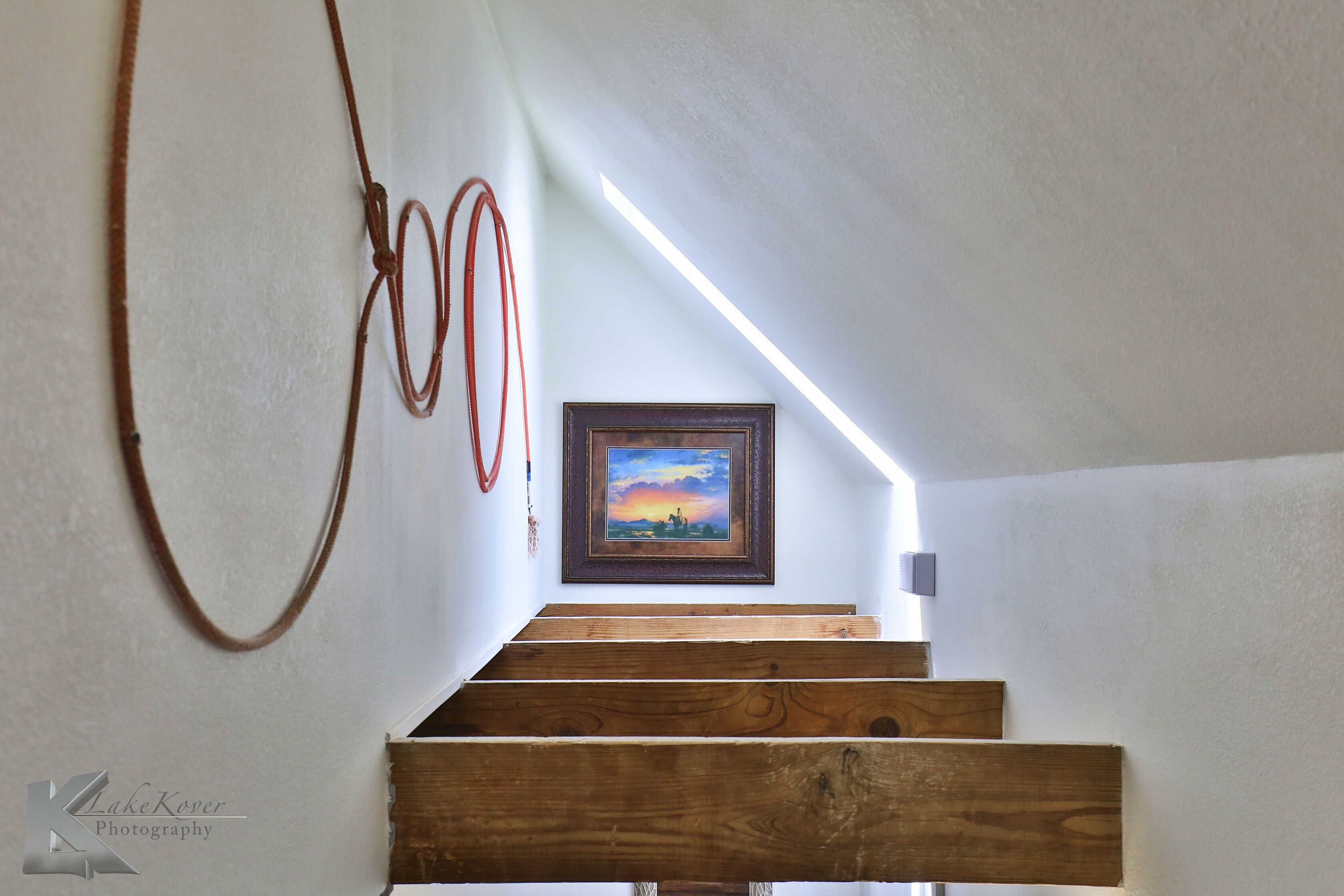 Una escalera de madera con un cuadro enmarcado en la parte superior.