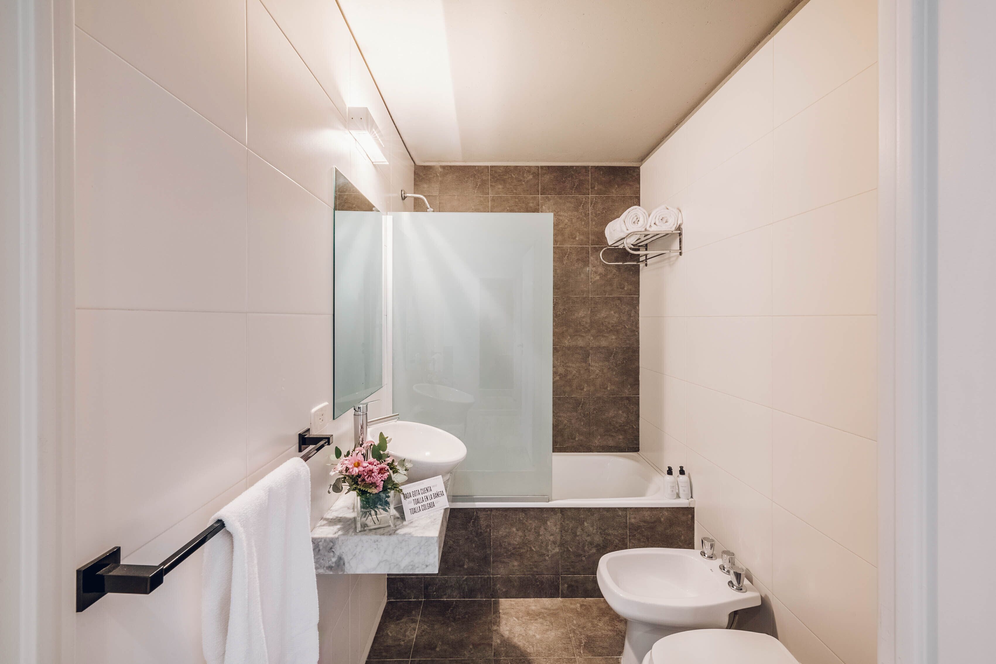 A modern bathroom with a glass shower enclosure, a vanity with a mirror, and two sinks.