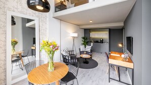 Un espace de vie moderne comprenant un coin repas, une cuisine et un salon avec un téléviseur.