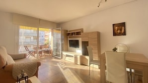Un appartement moderne comprenant un espace de vie, un coin repas et un balcon avec vue sur la ville.