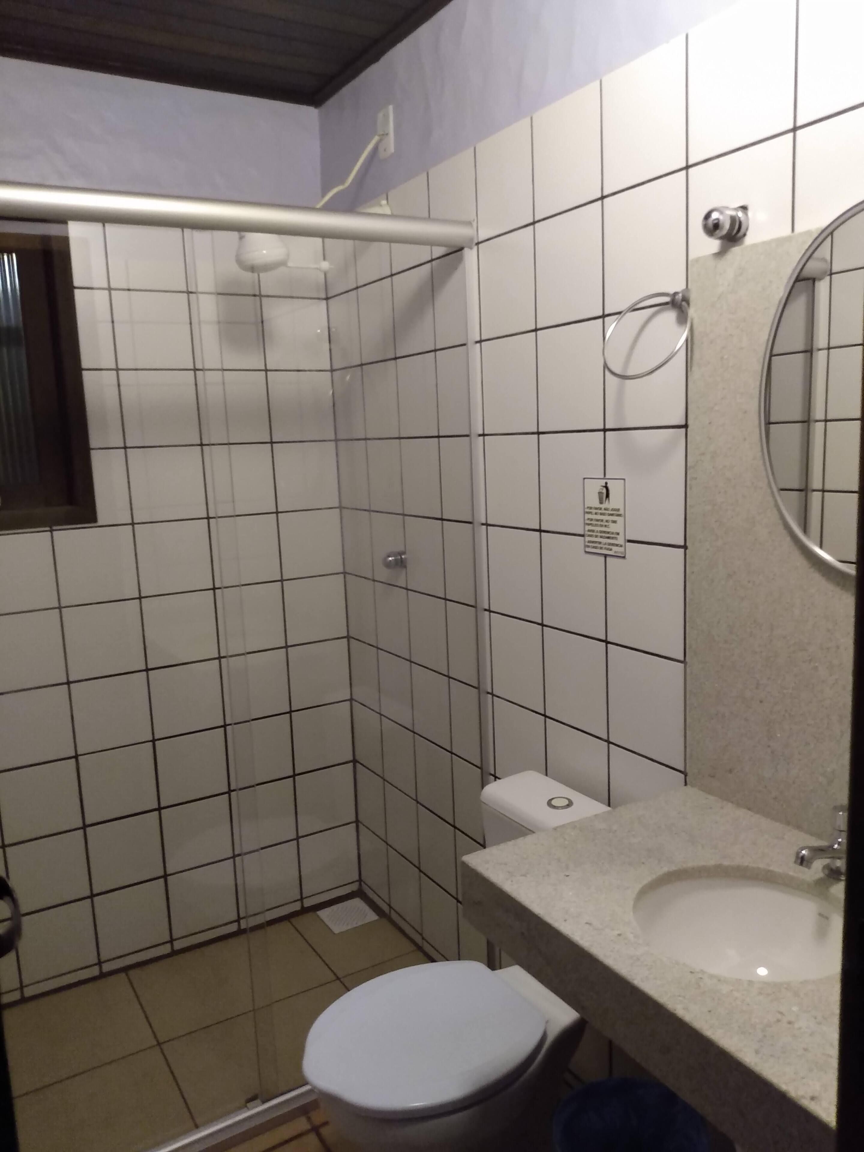 Un baño pequeño con inodoro, lavabo y zona de ducha.