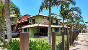 A row of two-story buildings with a sign indicating 'Condomínio' and 'Bairro'. - Condomínio Sargento Laranja (Garopaba)