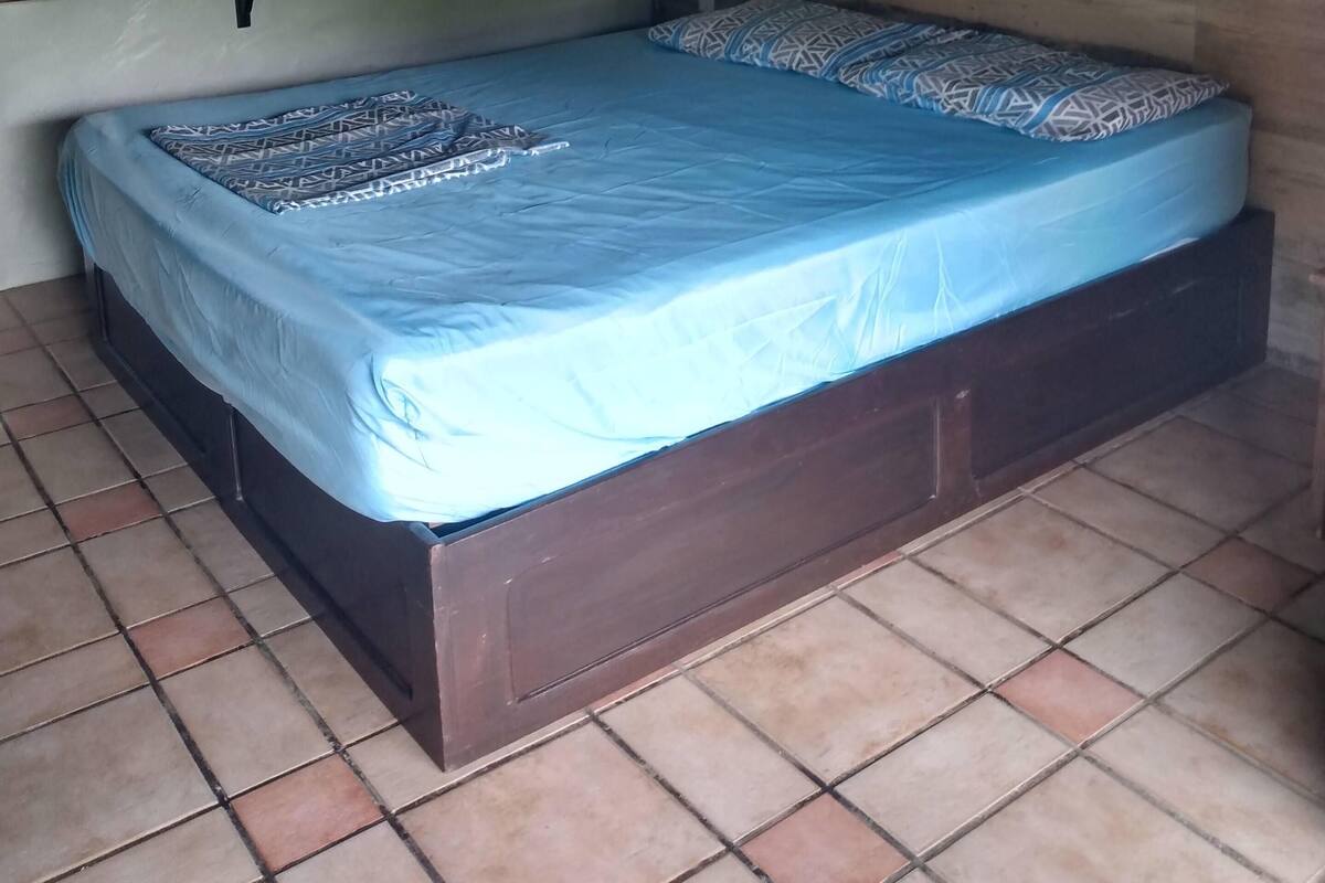 Un dormitorio con cama, ventilador de techo y estantería.