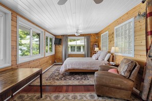 A bedroom with a bed, a sofa, a table, and a TV. - Summer Haven:"Tons of Outdoor Space" (Hammondsport)