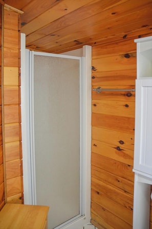 Una habitación con paneles de madera, una puerta blanca y una pequeña mesa de madera.