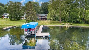 A dock extending into a calm body of water with a boat covered by a blue tarp. - Maya's Palace: Pet-Friendly Keuka Lake Escape! (Keuka Park)