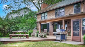 A two-story house with a covered patio, outdoor seating, and a grill. - Maya's Palace: Pet-Friendly Keuka Lake Escape! (Keuka Park)
