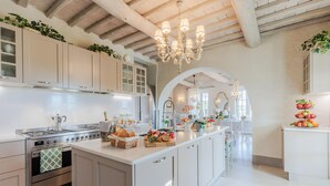 A modern kitchen with white cabinetry, a central island, and a chandelier.