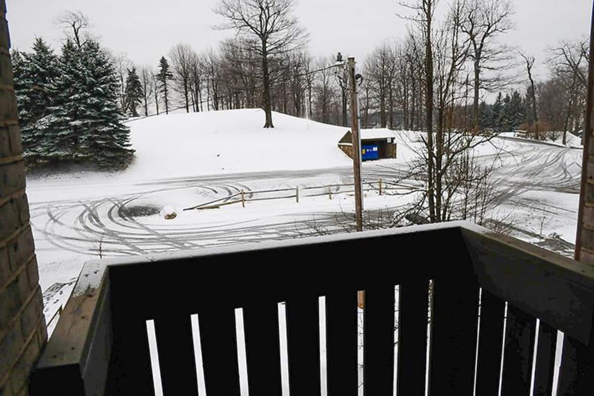 A snowy landscape with a road and a blue sign.
