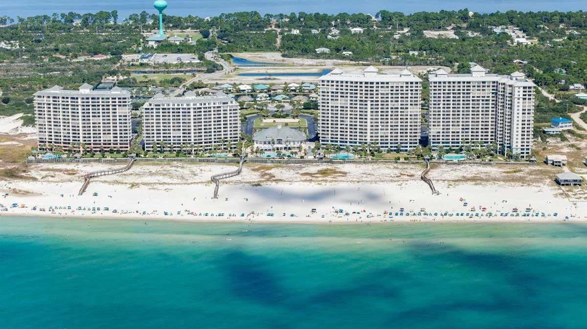 A coastal hotel complex with multiple high-rise buildings, a beach, and a water tower.
