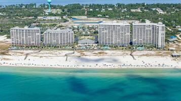 A coastal hotel complex with multiple high-rise buildings, a beach, and a water tower.