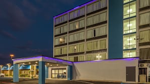 A multi-story hotel with a covered entrance, a parking lot, and a blue-lit exterior. - Super 8 by Wyndham Laredo (Laredo)