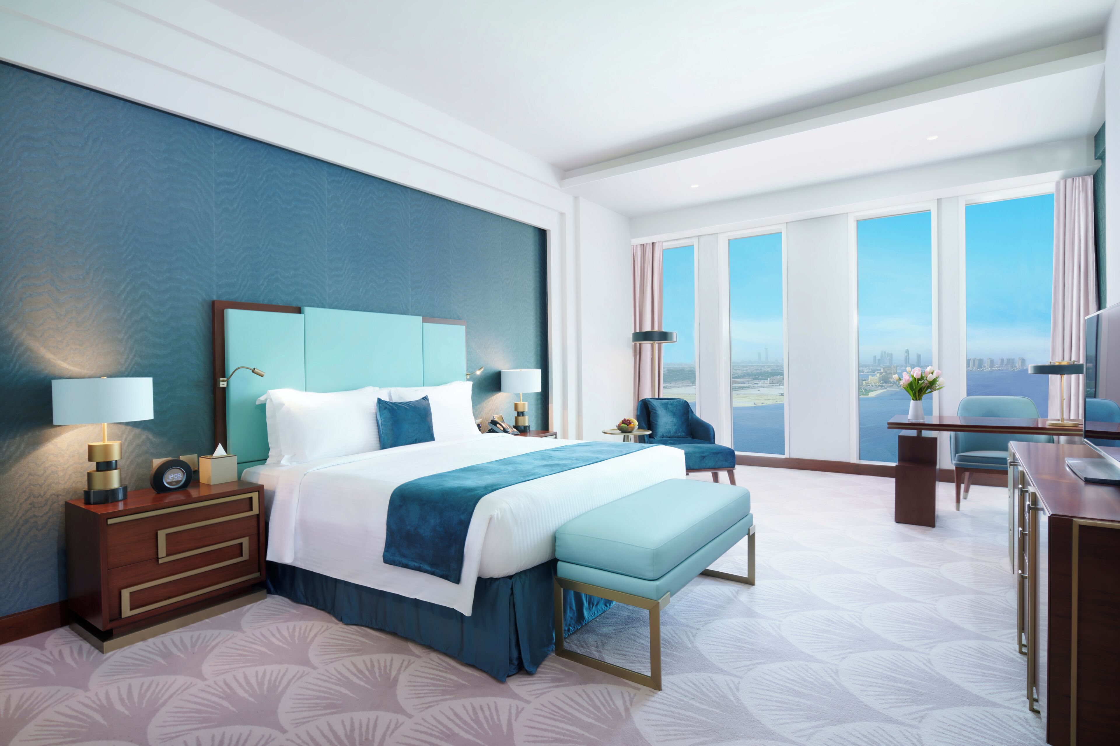 Ein modernes Hotelzimmer mit einem großen Bett, einem Schreibtisch und Blick auf die Stadt.