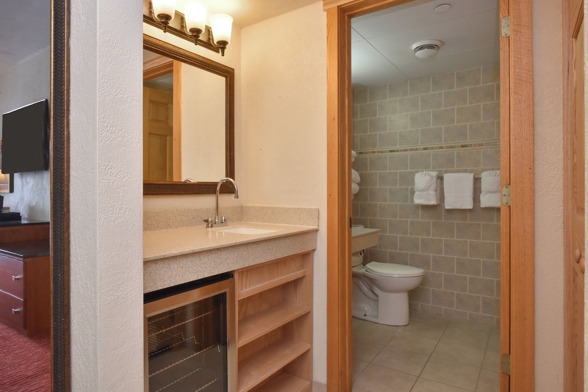 A bathroom with a sink, mirror, and toilet.