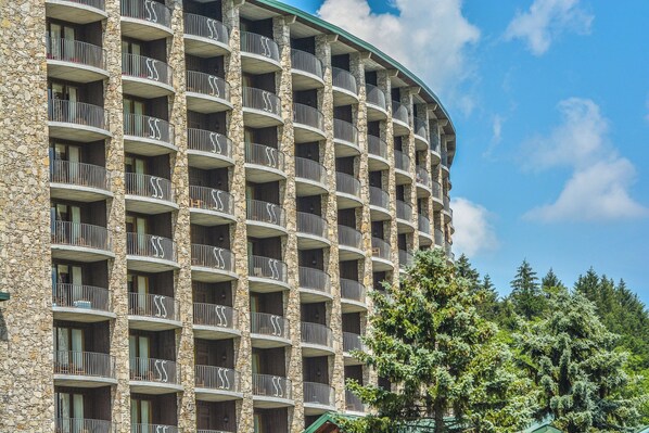 Un hotel de varios pisos con fachada de piedra y balcones.