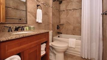 Une salle de bain équipée d’un lavabo, de toilettes, d’une baignoire et d’une douche.