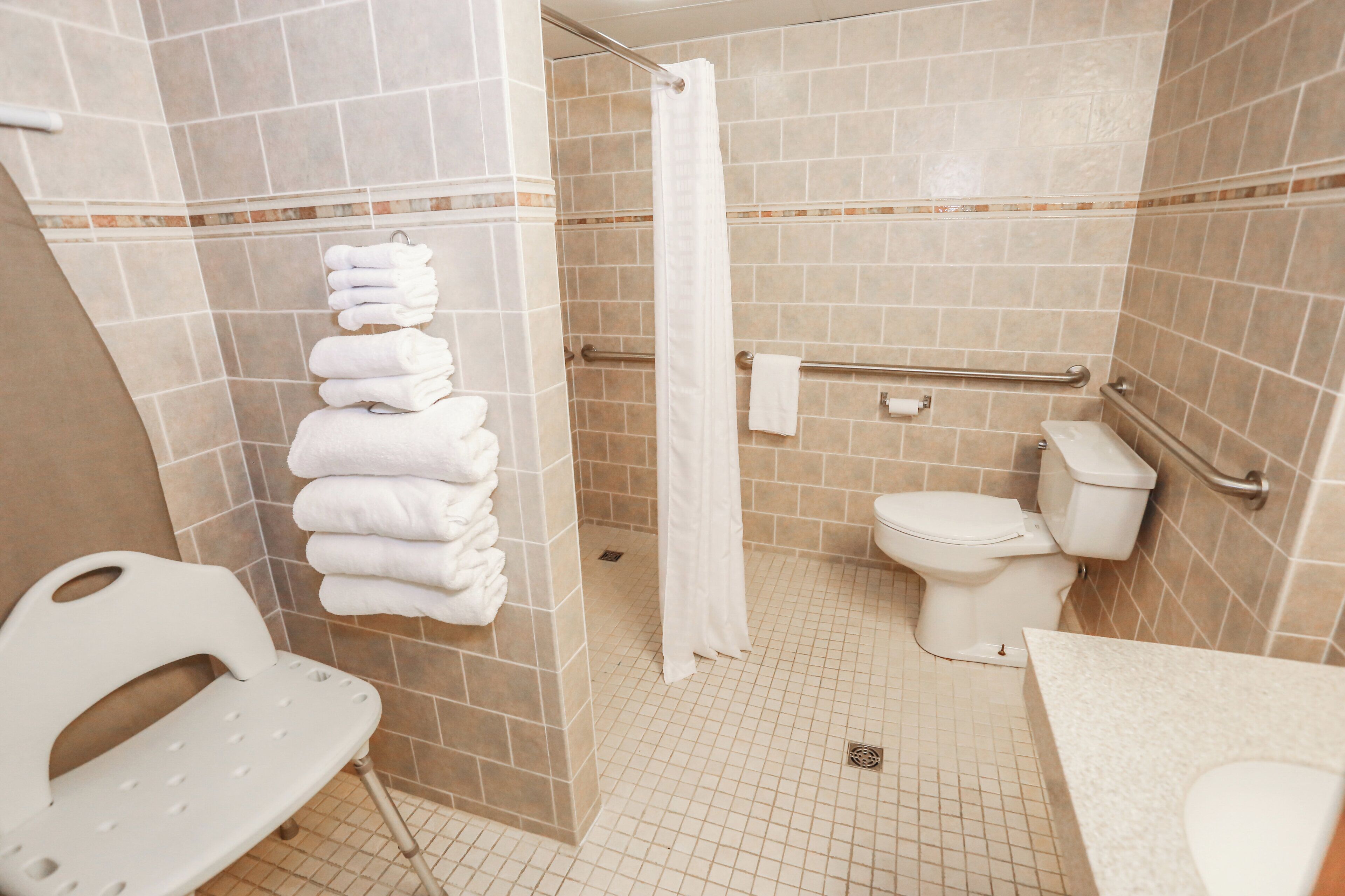 Ein Badezimmer mit Dusche, Toilette und einem Händetrockner.