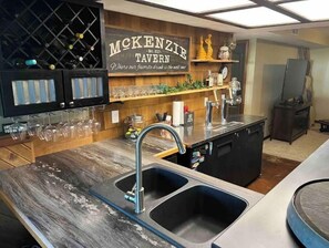 Experience the heart of the home at McKenzie Tavern, where a spacious kitchen area offers a wine rack and two sinks.