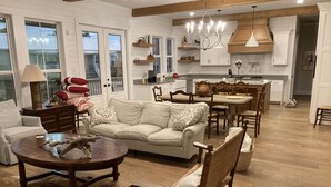 A spacious living room with a sofa, coffee table, and a dining area with a table and chairs. - Spacious 4 Bedroom House - 3/4 Mile to Round Top Center! (Round Top)