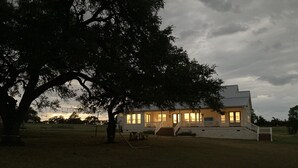 A two-story house with a porch and a large tree in front. - Spacious 4 Bedroom House - 3/4 Mile to Round Top Center! (Round Top)
