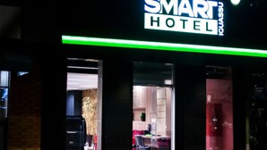 Entrada de un hotel con un cartel que dice "SMART HOTEL".