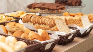 Un bufé con panes y pasteles varios.