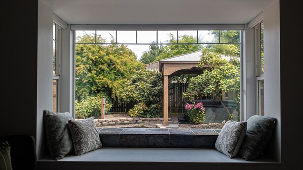 Una habitación con un amplio ventanal que da a un jardín.