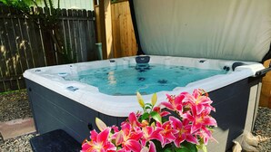 Un jacuzzi con un muelle de madera y una valla de madera al fondo.