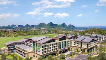 A modern hotel with multiple floors, large windows, and a central courtyard.