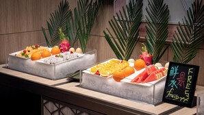 Dos bandejas de hielo con frutas y un cartel que indica frutas frescas.