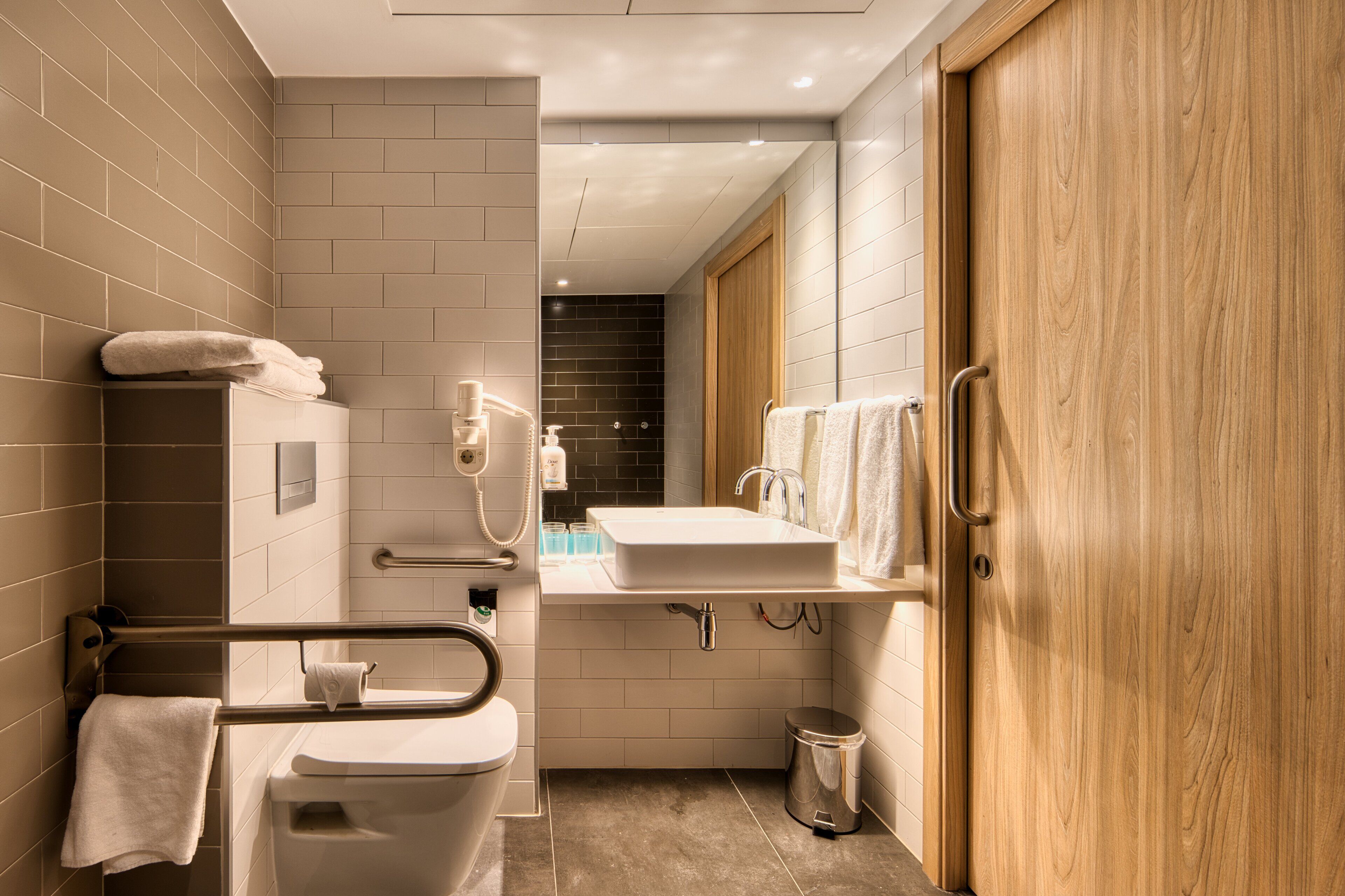 Un baño moderno con inodoro, lavamanos y ducha.
