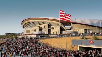 Um estádio com uma grande multidão, uma bandeira e um sinal de metrô.