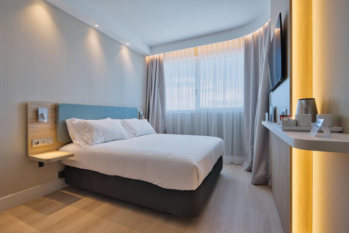 Premium bedding, desk, laptop workspace, blackout drapes