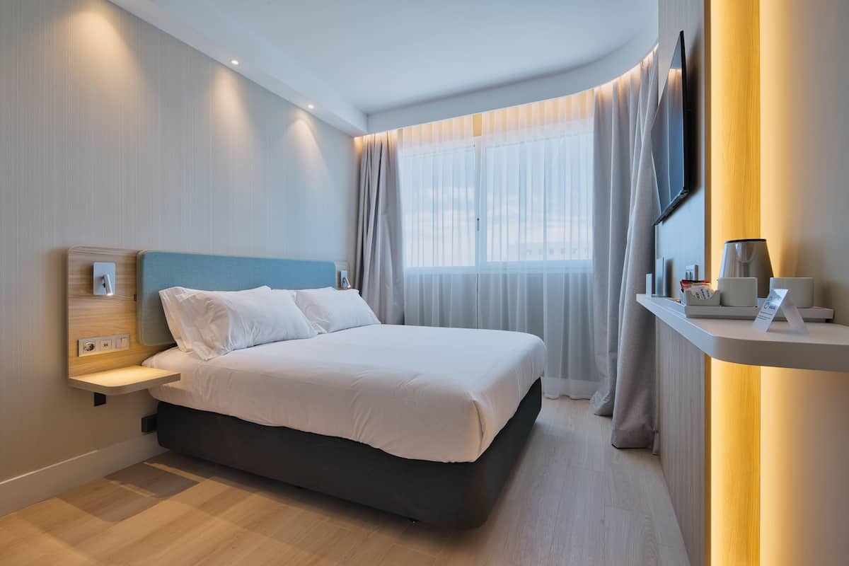 Premium bedding, desk, laptop workspace, blackout drapes