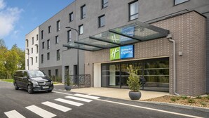Un bâtiment de la chaîne Holiday Inn Express, doté d’un design moderne, avec une façade en briques et de grandes fenêtres.