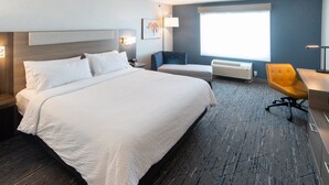A hotel room with a large bed, a desk, a chair, and a window with blinds. - Holiday Inn Express and Suites Moose Jaw by IHG (Moose Jaw)