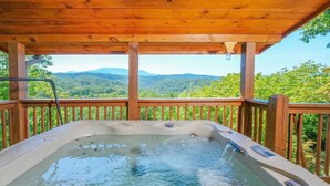 A hot tub with a wooden deck and a view of a forested mountain range. - NEW listing! INDOOR POOL, panoramic views, & game room - 15 min to Pigeon Forge (Sevierville)