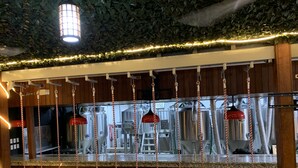 A bar area with a counter, hanging red lights, and industrial equipment in the background.
