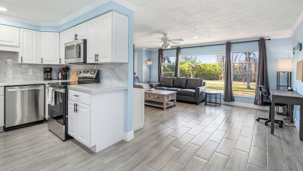 A modern kitchen with white cabinets, stainless steel appliances, and a central island. - Relaxing 4 bedroom home with heated Pool (Punta Gorda)