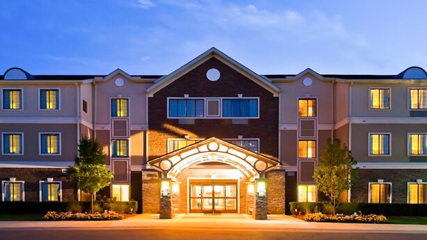 A multi-story hotel with a central entrance, large windows, and a symmetrical facade. - Free Breakfast Buffet. Pool, Hot Tub & Gym Access! (Novi)