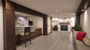A modern kitchen with a marble countertop, a built-in refrigerator, and a stone fireplace. - Free Breakfast Buffet. Pool, Hot Tub & Gym Access! (Novi)