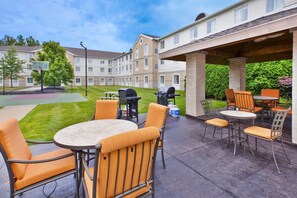 An outdoor patio area with a basketball court, barbecue grills, and outdoor seating. - Free Breakfast + 24-Hour Business Center + Gym (Mayfield Heights)