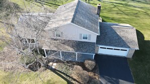 A residential house with a sloped roof, a garage, and a fenced yard. - Our Comfortable Neighborhood Home (Boalsburg)