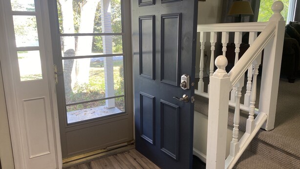 A dark blue door with a keypad lock, a white door next to it, and a white staircase with a balustrade. - Our Comfortable Neighborhood Home (Boalsburg)