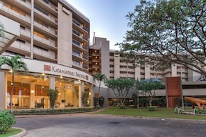 A hotel with a modern design, featuring multiple balconies and a prominent entrance with a glass facade.