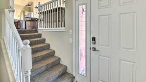Una escalera con barandilla blanca que lleva a una puerta con ventanal.