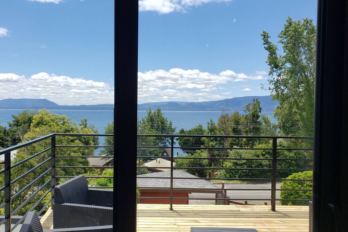 A balcony with a view of a lake and mountains.